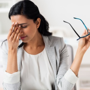 The TMJ and Eye Pain | Raleigh TMJ A young woman holding her hand to her pained eyes