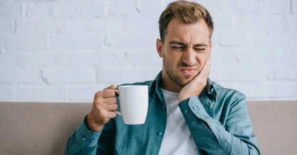 Woman in pain from TMJ wondering what causes TMJ flare ups