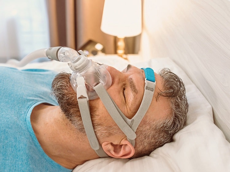 CPAP therapy a sleep appliance can replace A man asleep wearing a CPAP mask and hose, the therapy a custom sleep appliance can replace