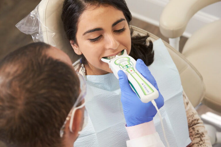 Patient biting on a T-Scan sensor held by a gloved clinician