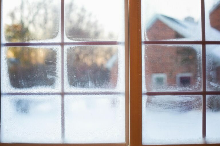 Frost and condensation covering the panes of a wooden window on a cold winter morning