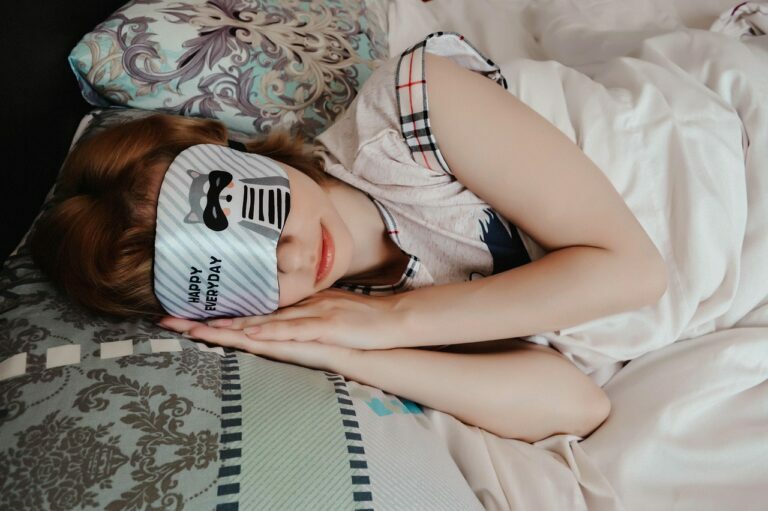 Woman resting in bed wearing a padded sleep mask over her eyes